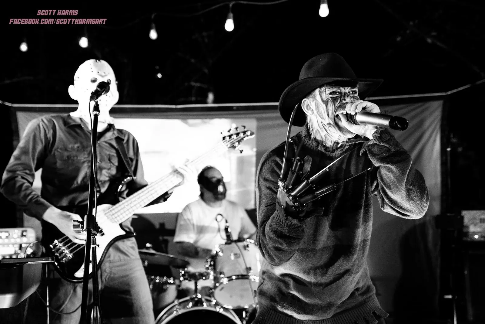 Freddy-style vocalist and masked bassist performing in black and white